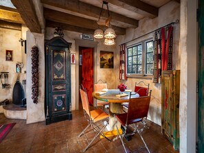 Un comedor rústico con una mesa y sillas de madera, un candelabro y vistas al exterior.
