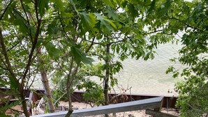 A wooden deck with a metal railing leading to a sandy beach area. - Lake Michigan Cottage w/ 265 ft of Private Beachfront! Perfect family getaway!  (Manistee)