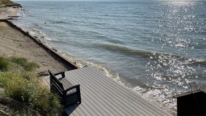 A wooden deck with a view of the ocean. - Lake Michigan Cottage w/ 265 ft of Private Beachfront! Perfect family getaway!  (Manistee)