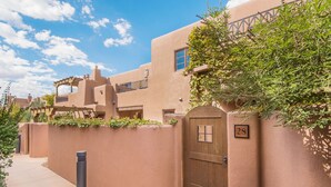 A stucco building with a wooden door, a window, and a number '28' sign. - El Corazon de Santa Fe | Patios, Private Balcony (Santa Fe)