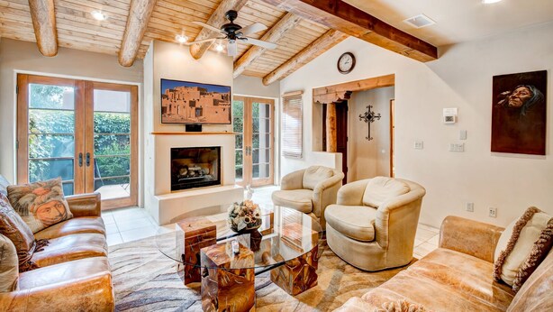 A spacious living room with a fireplace, comfortable seating, and a ceiling fan. - El Corazon de Santa Fe | Patios, Private Balcony (Santa Fe)