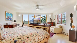 Un'ampia camera da letto con un letto grande, una scrivania, una sedia e una televisione.