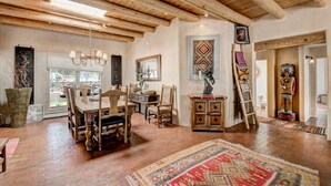 A spacious room with a wooden dining table, chairs, and a large rug. - Moonstar | Pet Friendly, Rooftop Deck, 360 Views! (Santa Fe)