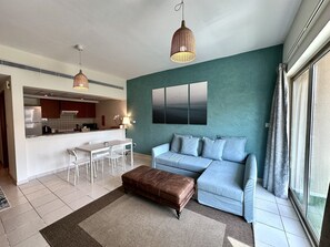 Una sala de estar moderna con un sofá, una mesa de centro y un comedor con sillas y una mesa.