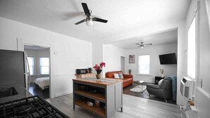 A modern apartment with a kitchen, dining area, living room, and a bedroom. - FRESHLY RENOVATED 2 BR APARTMENT! (Ansonia)