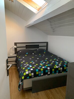 Cozy retreat with a single bed, bedside table, and skylight.