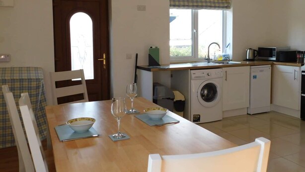 A compact kitchen with a washing machine, a microwave, and a sink. - Delightful Bungalow Near Skibbereen & Baltimore (Skibbereen)