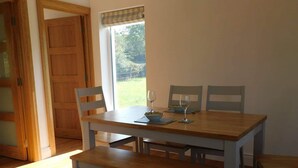 A dining area with a wooden table and four chairs. - Delightful Bungalow Near Skibbereen & Baltimore (Skibbereen)
