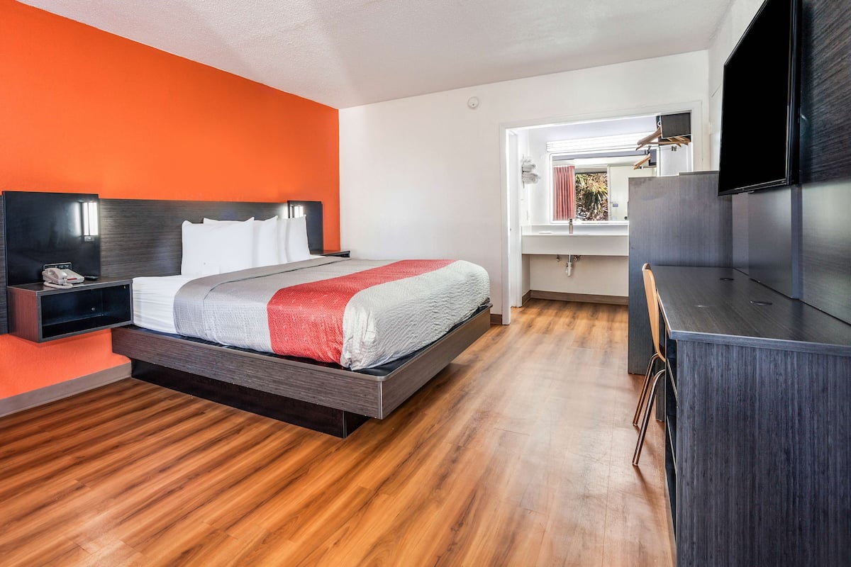 Une chambre d’hôtel moderne équipée d’un lit, d’un bureau et d’une télévision.