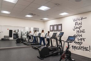 A gym with treadmills, stationary bikes, and a wall with motivational workout phrases. - The Bradley Hotel (Fort Wayne)