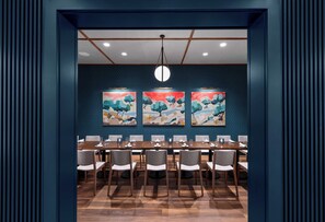 A conference room with a long table, chairs, and three abstract paintings on the wall. - The Bradley Hotel (Fort Wayne)