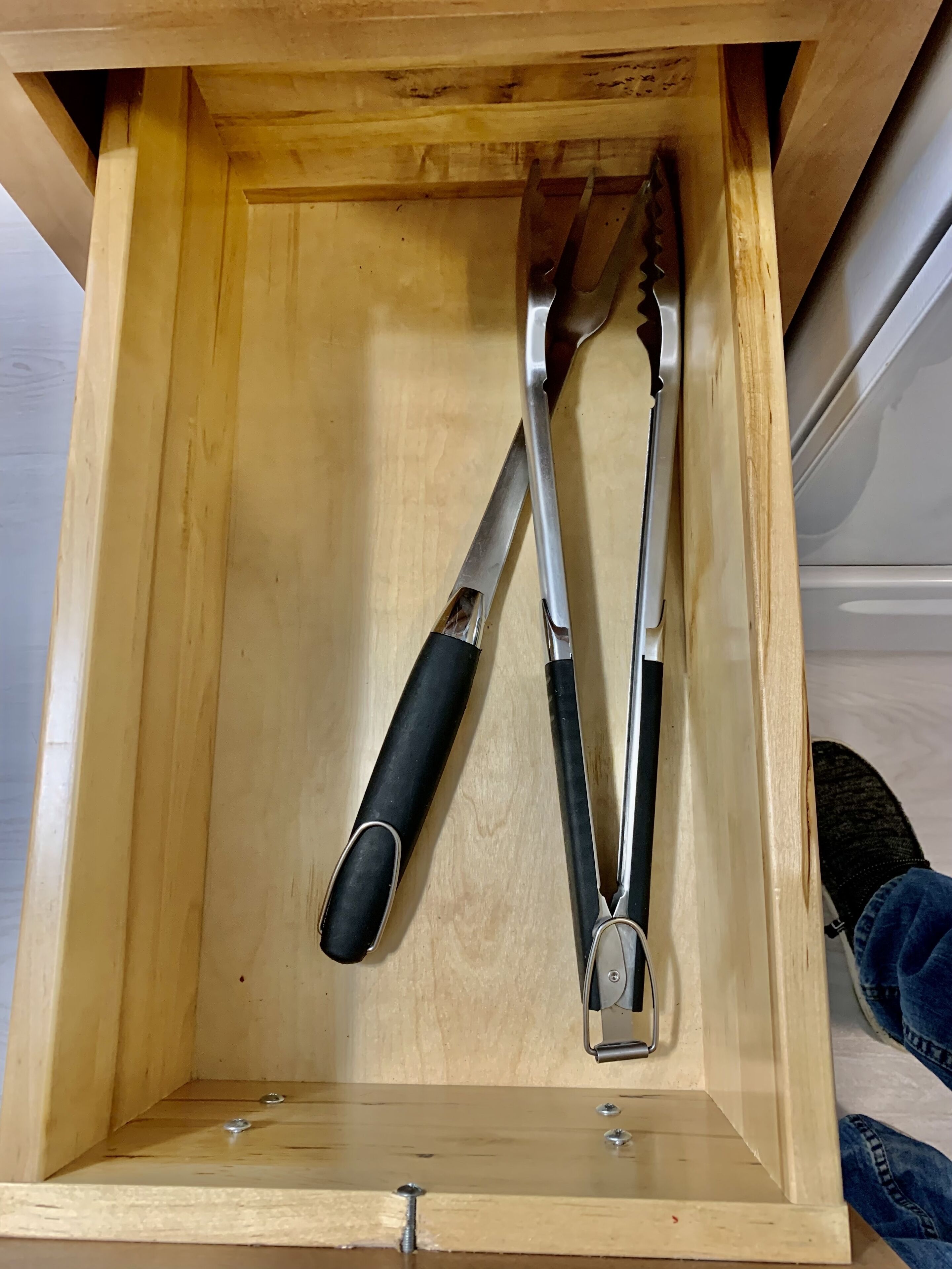 Un tiroir en bois contenant deux outils en métal.