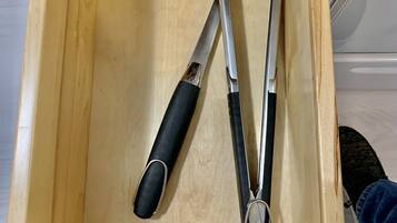 Un tiroir en bois contenant deux outils en métal.