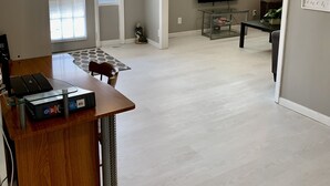 Un salón amplio con ventilador de techo, televisor y comedor con mesa y sillas.