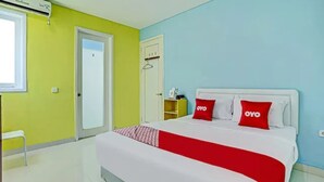 Une chambre d’hôtel avec un lit, une armoire, une petite table et une fenêtre.