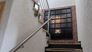 A staircase with metal railings and a window with a brick wall behind it. - Loftstyle Panorama Bödefeld (Schmallenberg)