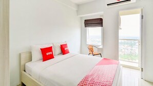 Una habitación de hotel con cama, ventana y vista a la ciudad.