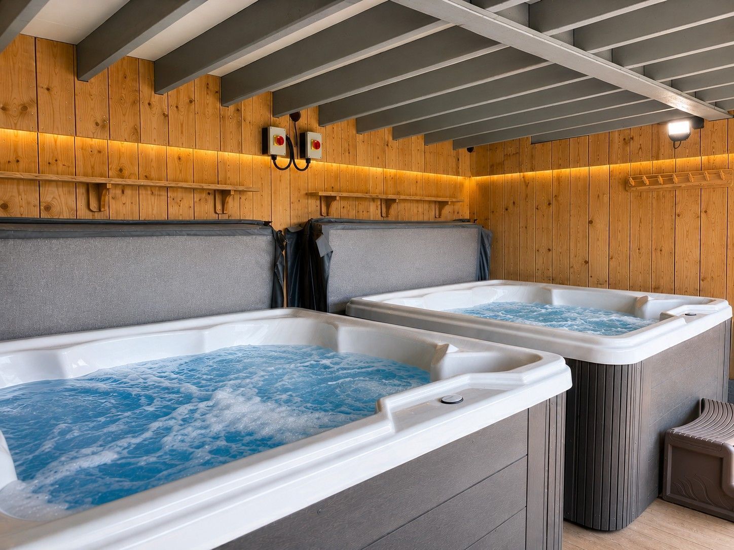 Dos jacuzzis en una habitación de madera con vigas a la vista.