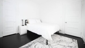 A bedroom with a bed, nightstand, and wardrobe. - ENTIRE APARTMENT RECENTLY RENOVATED 2BR (Ansonia)