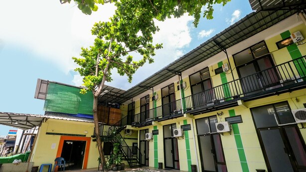 A multi-story building with balconies, air conditioning units, and a staircase leading to the upper floors. - OYO 3263 House 140 (Baturetno)