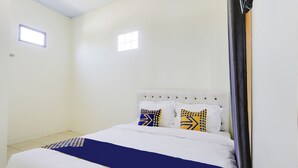 A bedroom with a bed, white walls, two small windows, and a curtain. - Spot ON 3993 Zidney 2 Syariah (Salatiga)