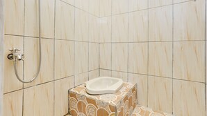 A small, tiled bathroom with a shower, a toilet, and a sink. - Spot ON 3993 Zidney 2 Syariah (Salatiga)