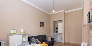 Un salón moderno con comedor, que incluye un sofá, una mesa de centro y un desayuno con jugo de naranja y pastelería.