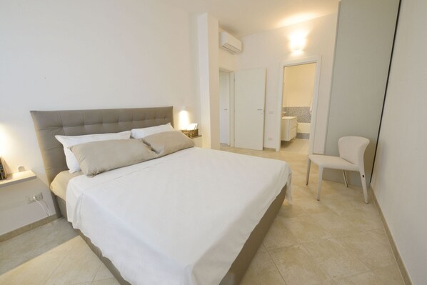 Une chambre à coucher avec un lit, une table de chevet et une chaise.