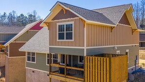 A two-story house with a balcony, a satellite dish, and a visible deck area. - Chateau Bliss (Gatlinburg)