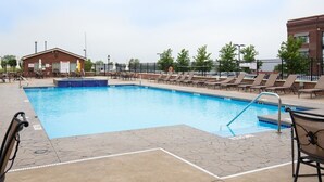 A swimming pool with lounge chairs and a building in the background.