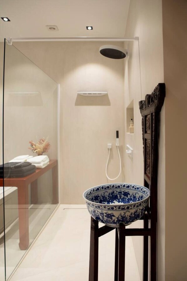 A modern bathroom with a glass shower enclosure, a white sink with a blue decorative bowl, and a wooden cabinet. - Wabi Sabi B&B - a Japanese Sleep Oasis in Belgium (Peer)