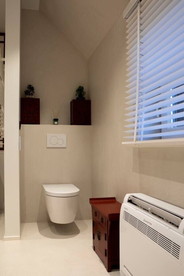 Un baño pequeño con inodoro, un armario y un calentador.