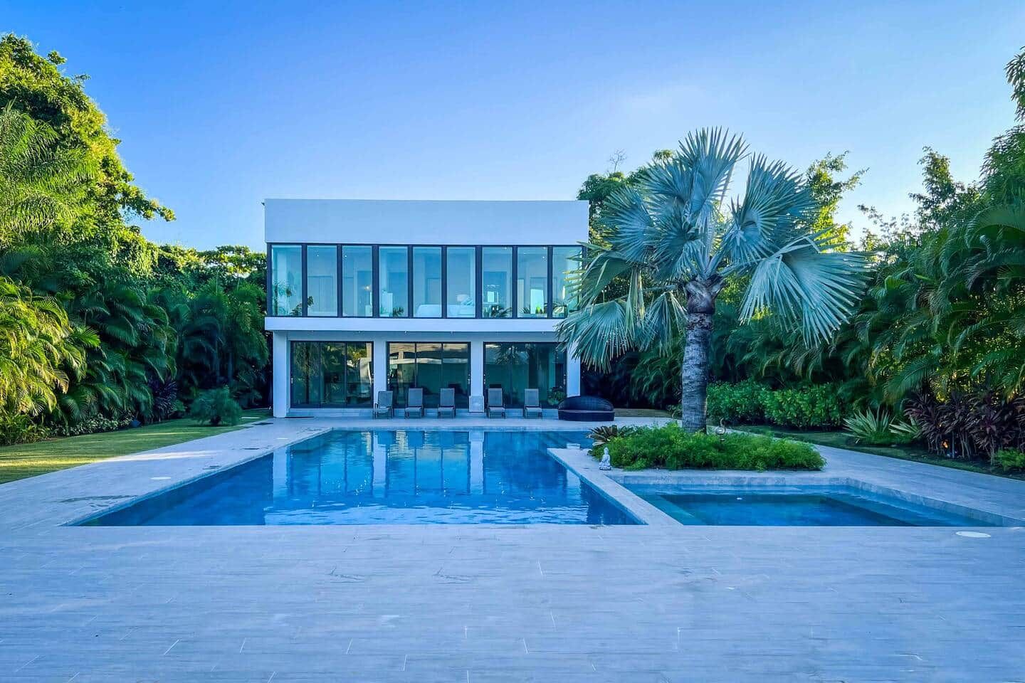 A modern two-story building with a large rectangular pool in front.