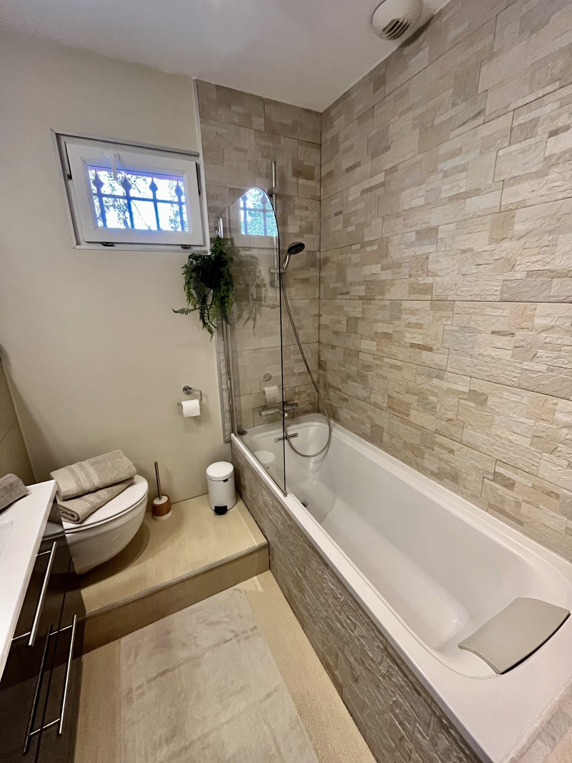 A modern bathroom with a bathtub, a toilet, and a sink.