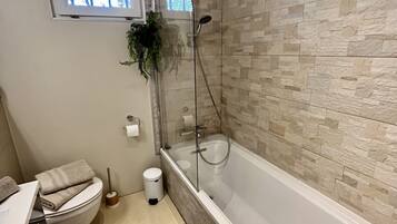 A modern bathroom with a bathtub, a toilet, and a sink.