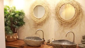 A bathroom with two stone sinks, wicker mirrors, a potted plant, and a small Buddha statue. - Villa Mathis (Mouans-Sartoux)