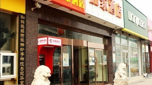 A storefront with signage in a foreign language, a red awning, and two white lion statues in front. - Home Inn Hotel Beijing Huoying Subway Station (Beijing)
