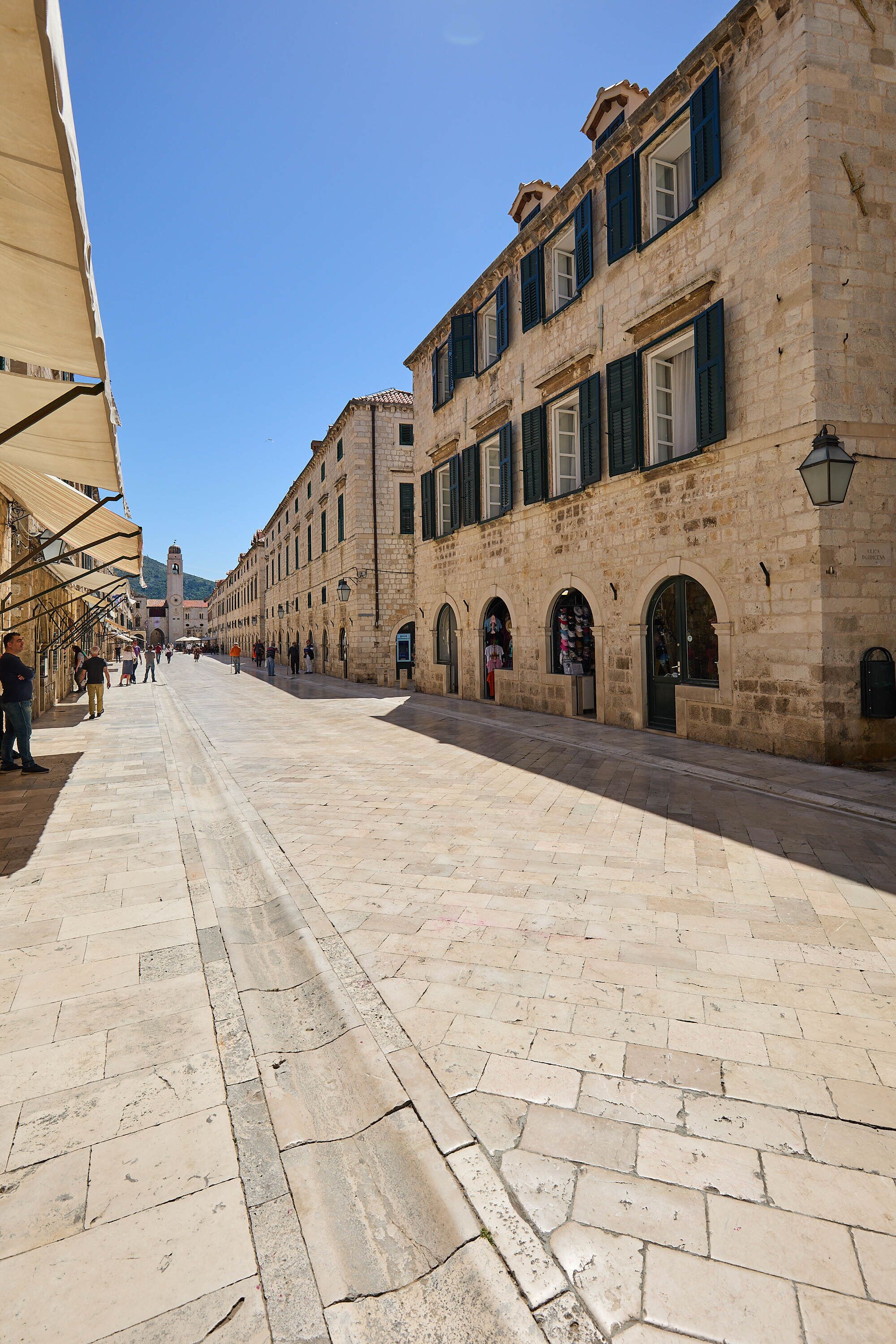 A historic stone building with arched doorways and a tiled courtyard.