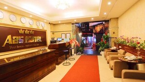 A hotel reception area with a reception desk, seating area, and a corridor leading to the entrance. - Hanoi Palace Hotel (Hanoi)