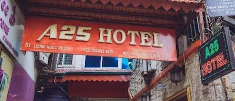 A hotel entrance with a red awning and a sign that reads 'A25 HOTEL'.