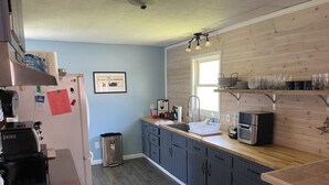 A modern kitchen with a wooden countertop, a stainless steel refrigerator, and a sink.