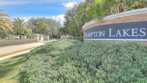 Un área ajardinada con un letrero que dice 'Hampton Lakes'.