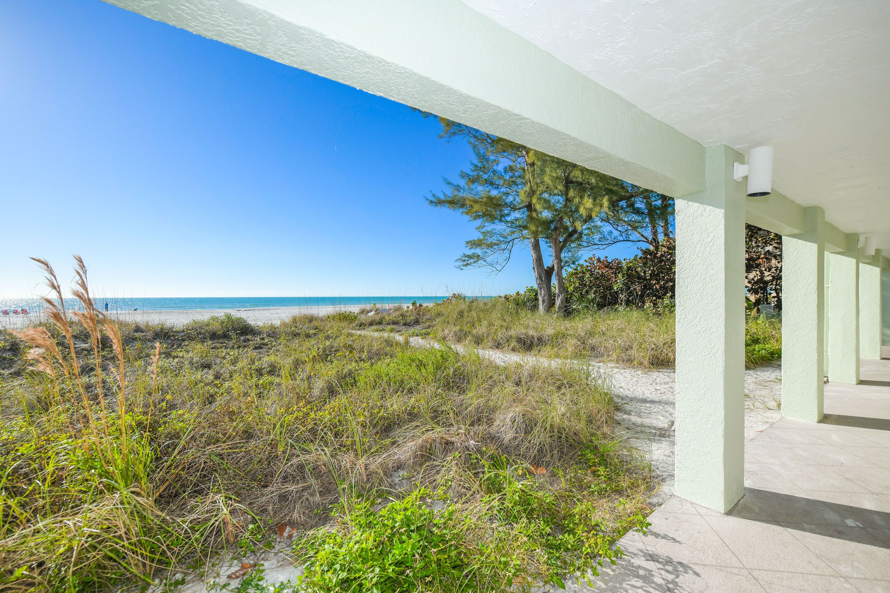A covered outdoor area with a view of the beach and ocean.