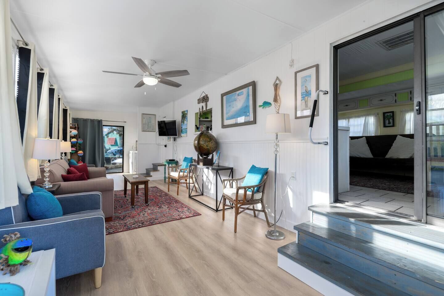 A modern living room with a sofa, chairs, a coffee table, a globe, and a television.
