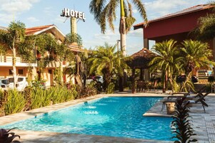 Una piscina al aire libre, sillones reclinables de piscina