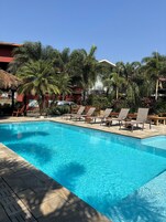 Una piscina al aire libre, sillones reclinables de piscina