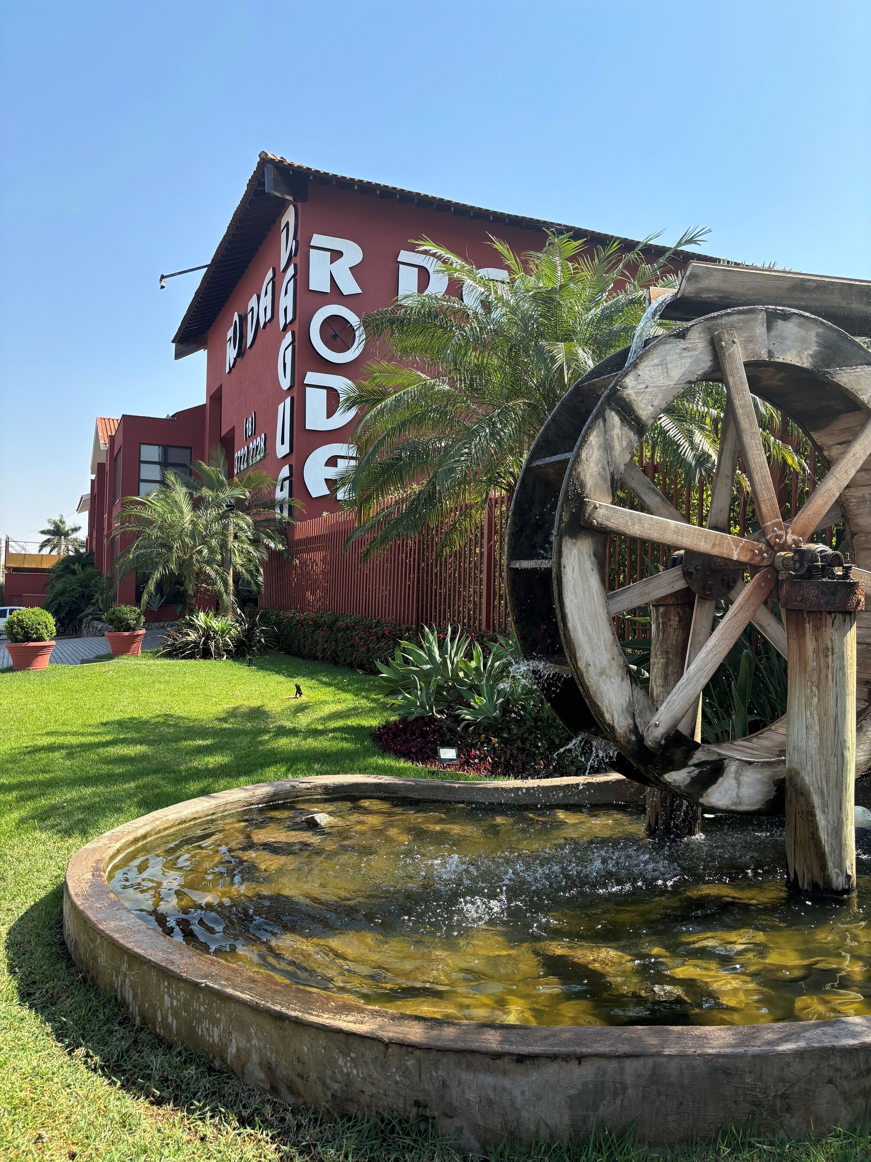 Un edificio con una gran rueda hidráulica y un letrero que dice "RODE".