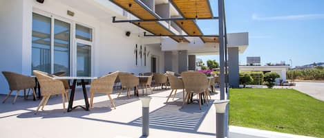 An outdoor patio with wicker furniture and a pergola structure.