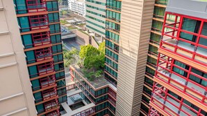 A high-rise building with multiple balconies, a courtyard with a pool, and surrounding greenery. - Condo magnifico in the heart of the Biltmore (Phoenix)