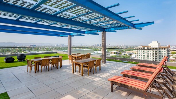 A rooftop patio with a pergola, outdoor seating, and a view of the cityscape. - Condo magnifico in the heart of the Biltmore (Phoenix)